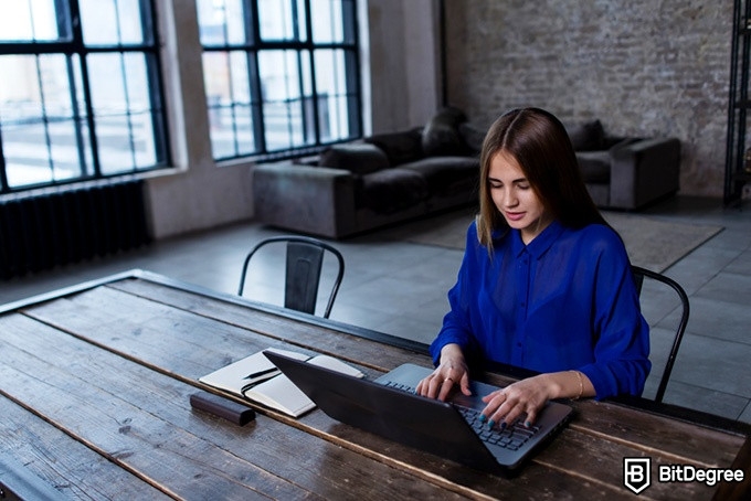 Cursos de Python Online: Una mujer feliz detrás de un computador.